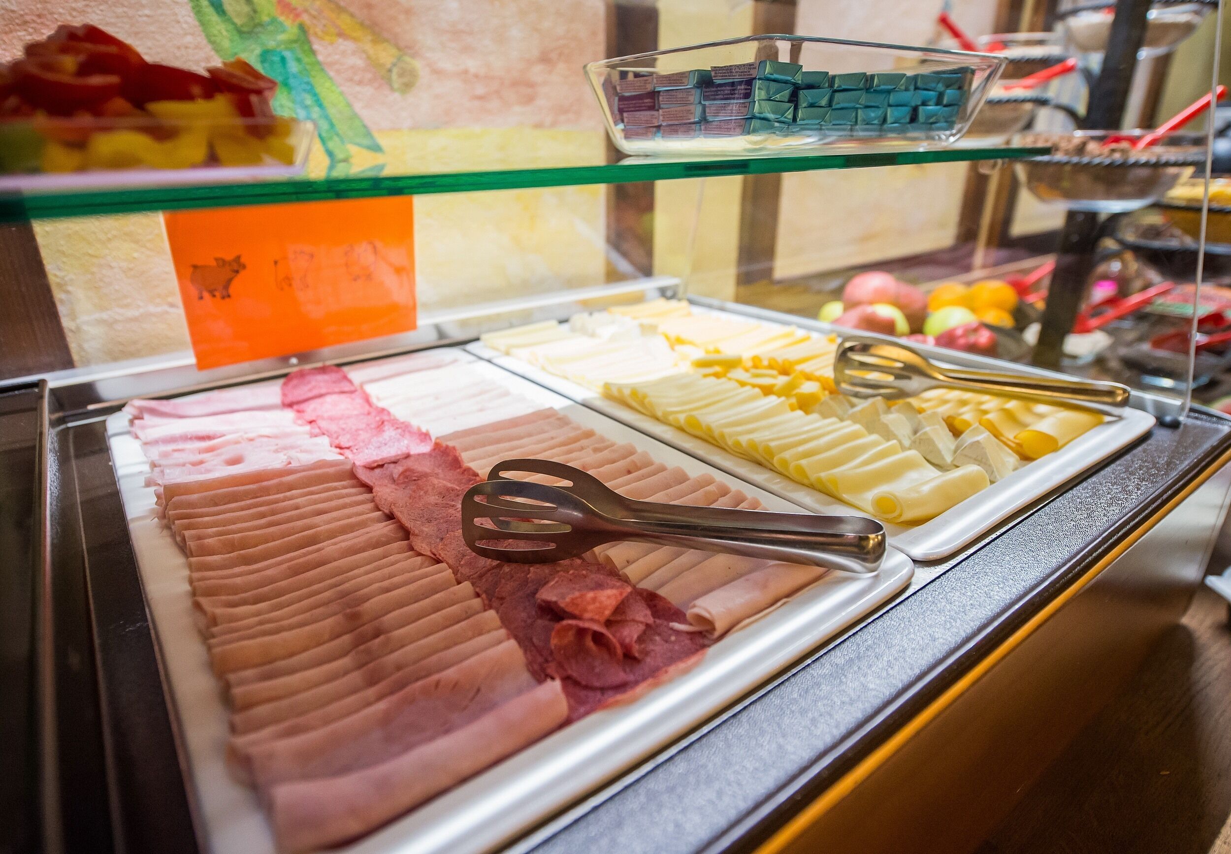 Un buffet proposant une variété de plats, notamment des viandes et des fromages coupés en tranches, présentés sur des plateaux.
