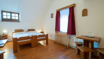 A bedroom with a wooden bed, a desk, and a radiator.