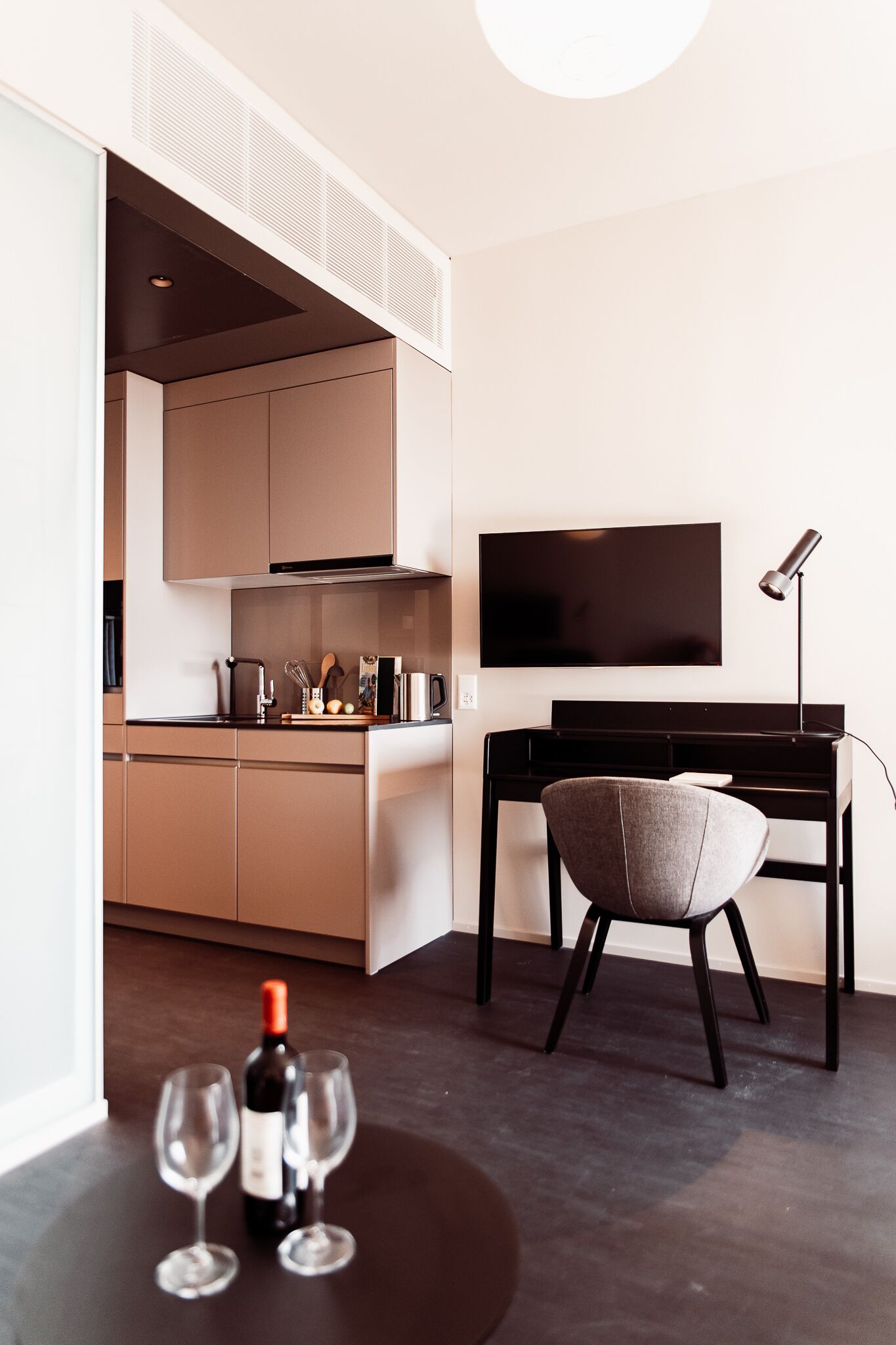 Een moderne keuken met een flatscreen televisie, een eettafel en een stoel.