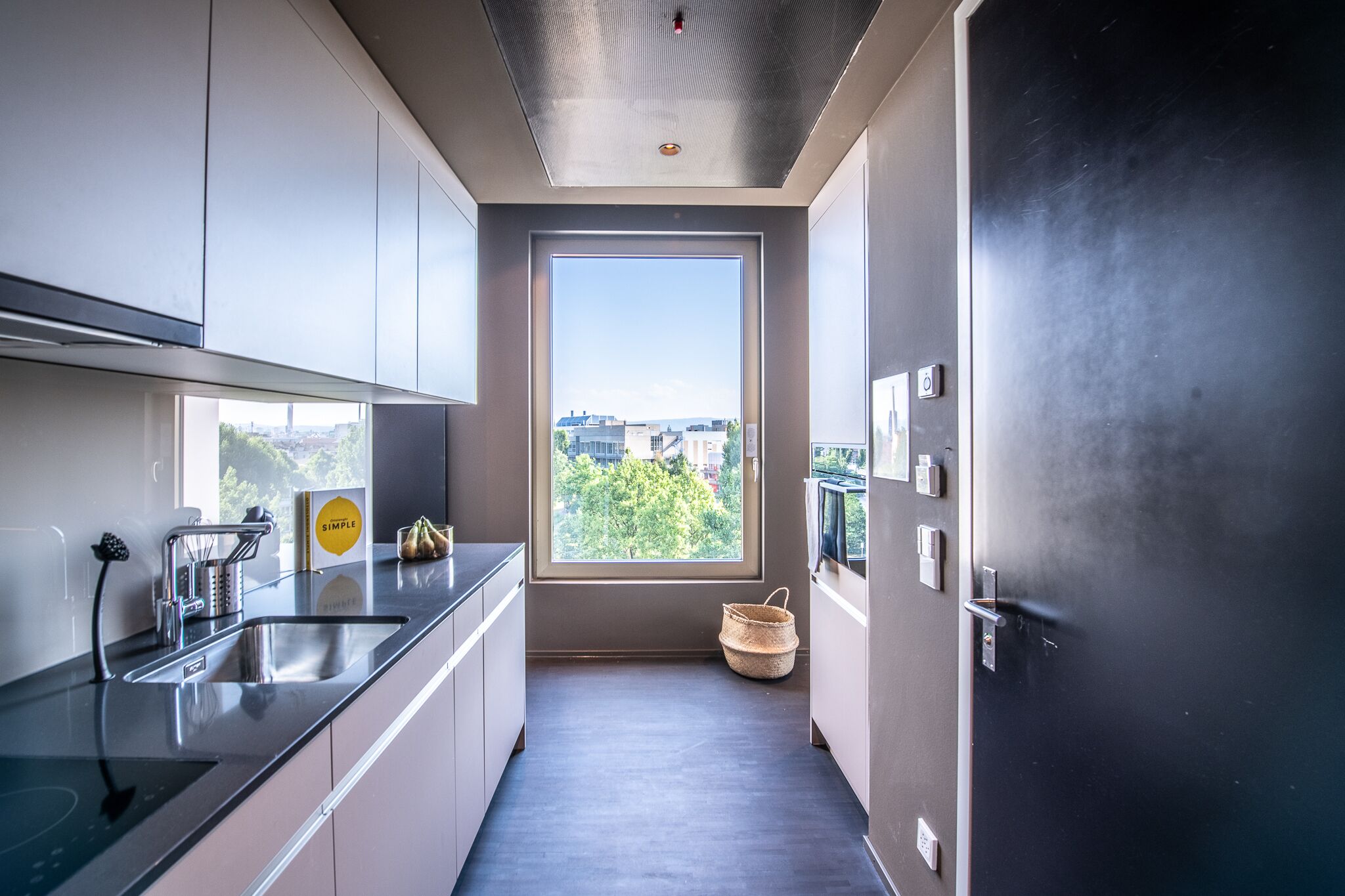 Una cocina moderna con un ventanal grande, electrodomésticos de acero inoxidable y un diseño minimalista.