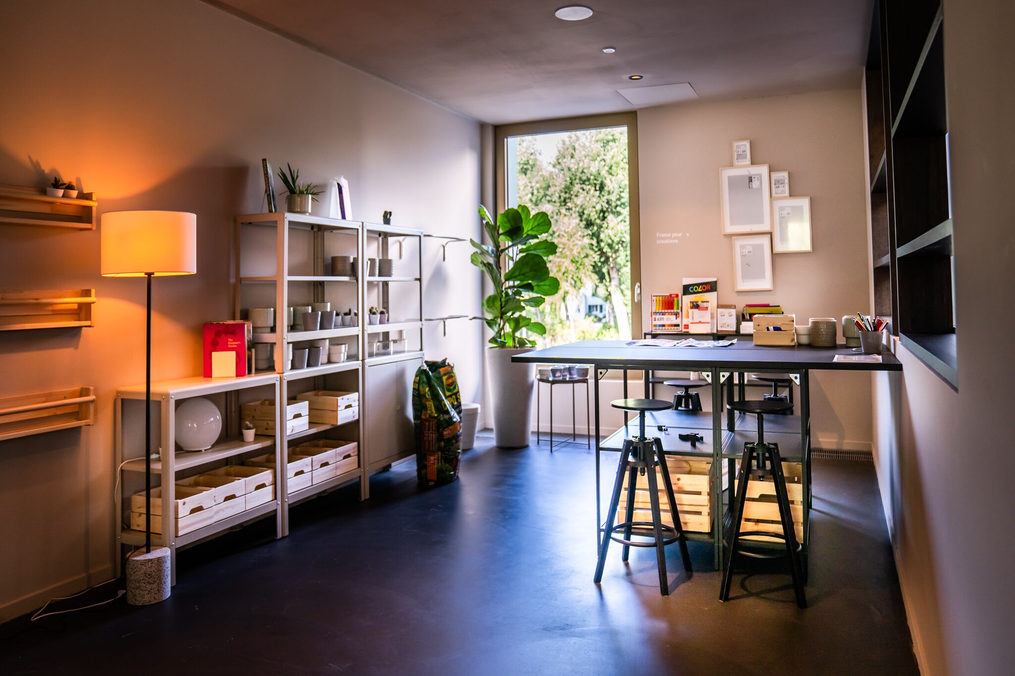 Una cocina moderna con una isla central, taburetes de bar y un ventanal amplio.