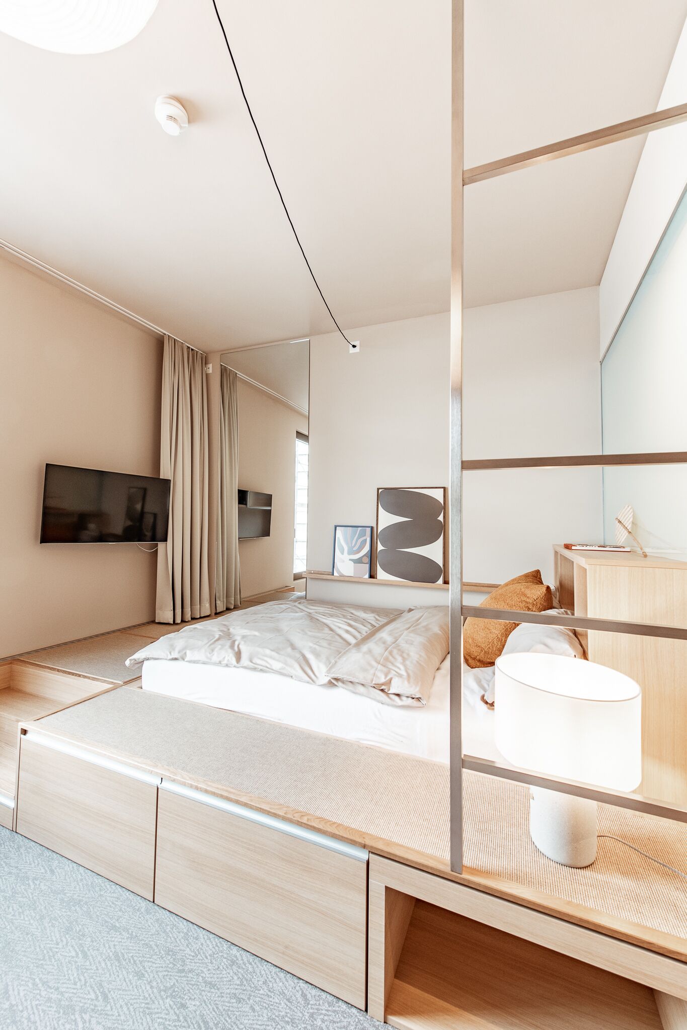 Ein modernes Schlafzimmer mit Bett, Nachttisch, Lampe und Kunstwerk.