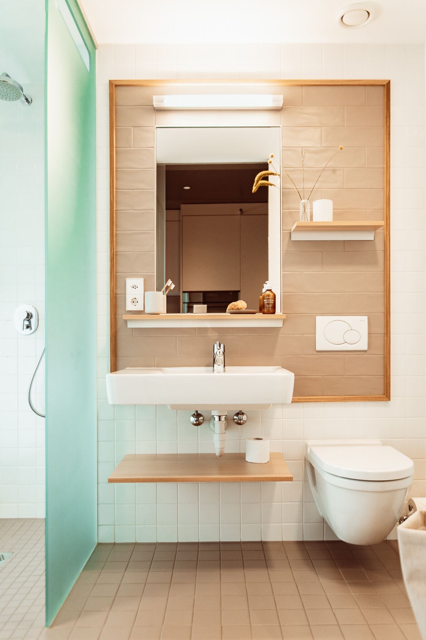 A modern bathroom with a white sink, a mirror, a toilet, and a shower.