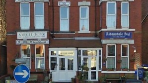 A row of red brick buildings with signage for 'Aldansdale Hotel' and 'Aldansdale House'.