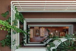 A modern outdoor seating area with a built-in bench and a small table, surrounded by potted plants. -  Hotel Pantanha Nature & Fitness (Nelas)