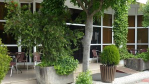 A building with outdoor seating and potted plants.