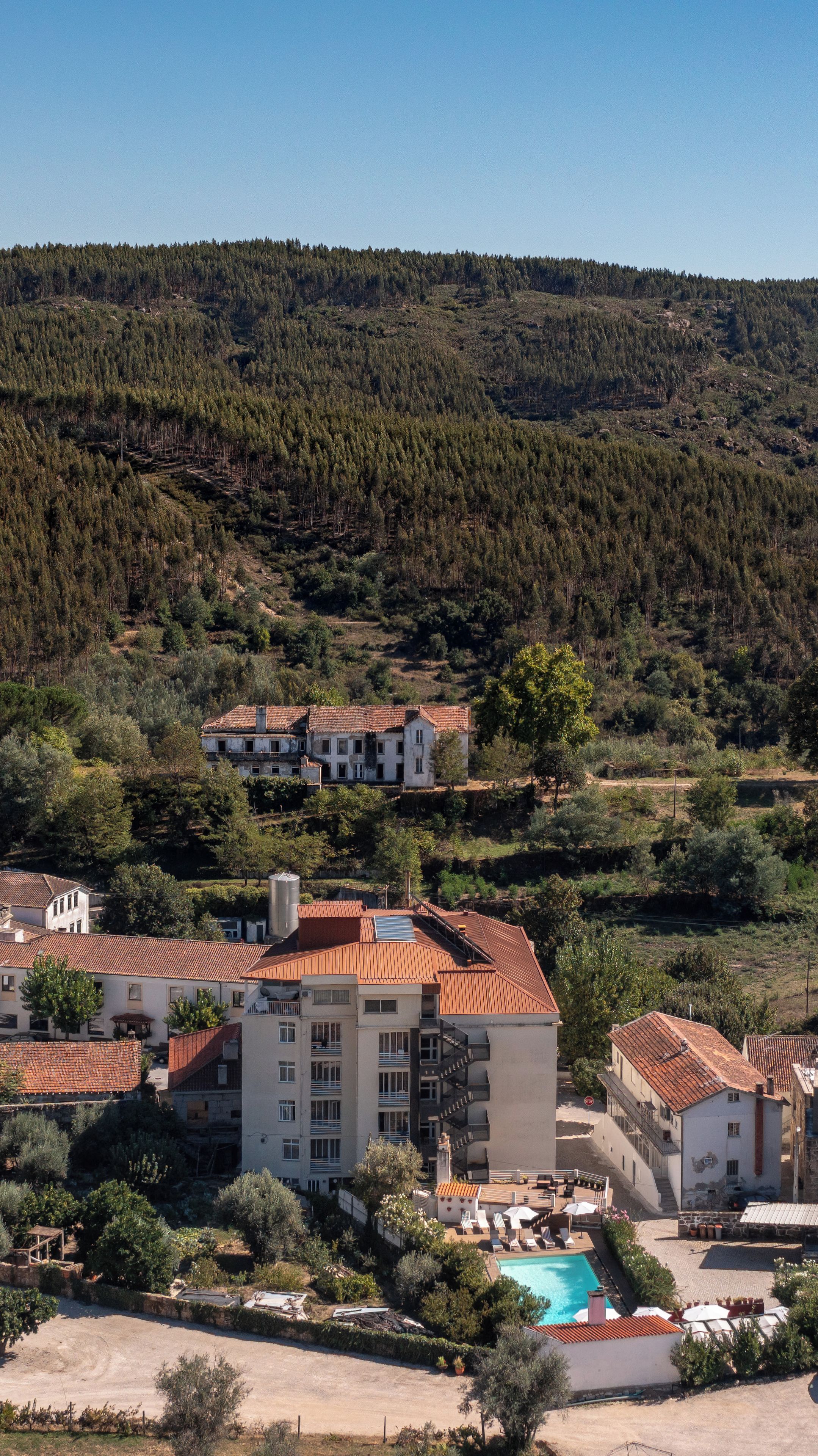 Un barrio residencial con un edificio grande que tiene varios balcones y una piscina.