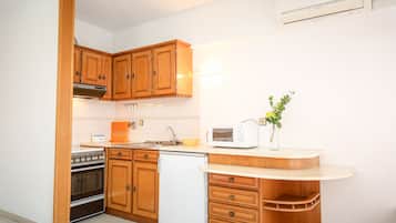 A kitchen with wooden cabinets, a stove, a dishwasher, and a microwave.