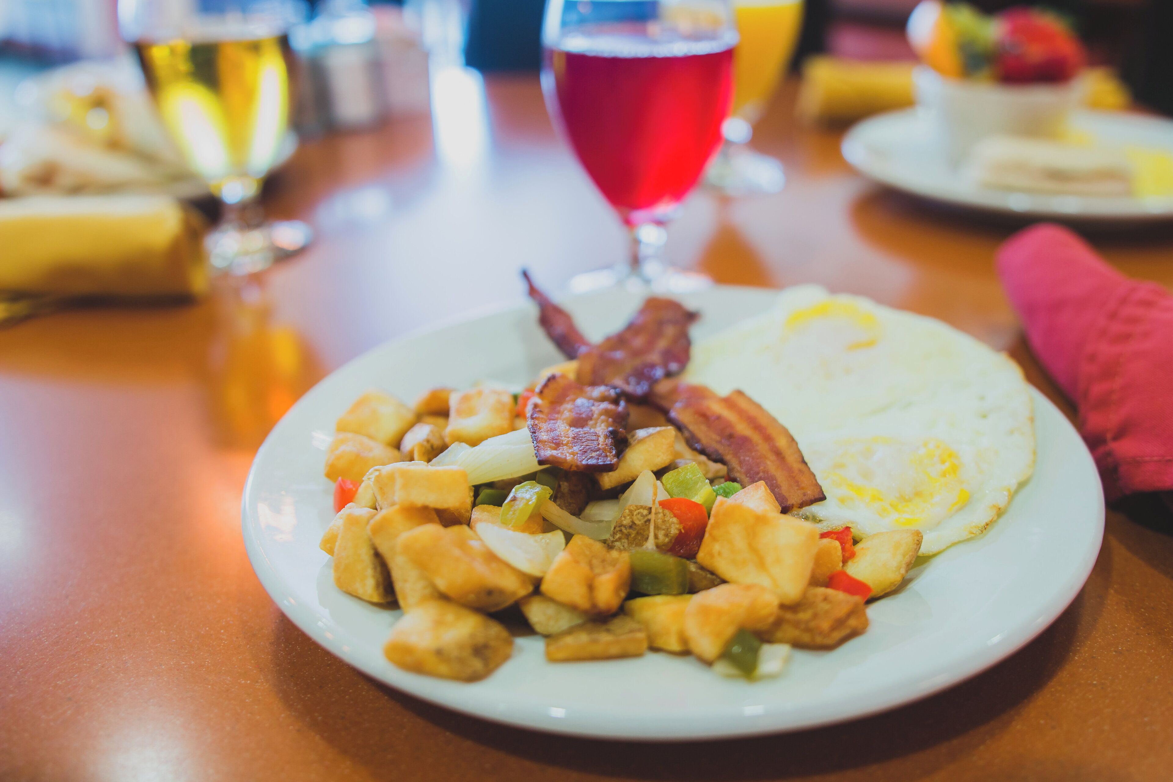 A plate of food with bacon, eggs, and vegetables.