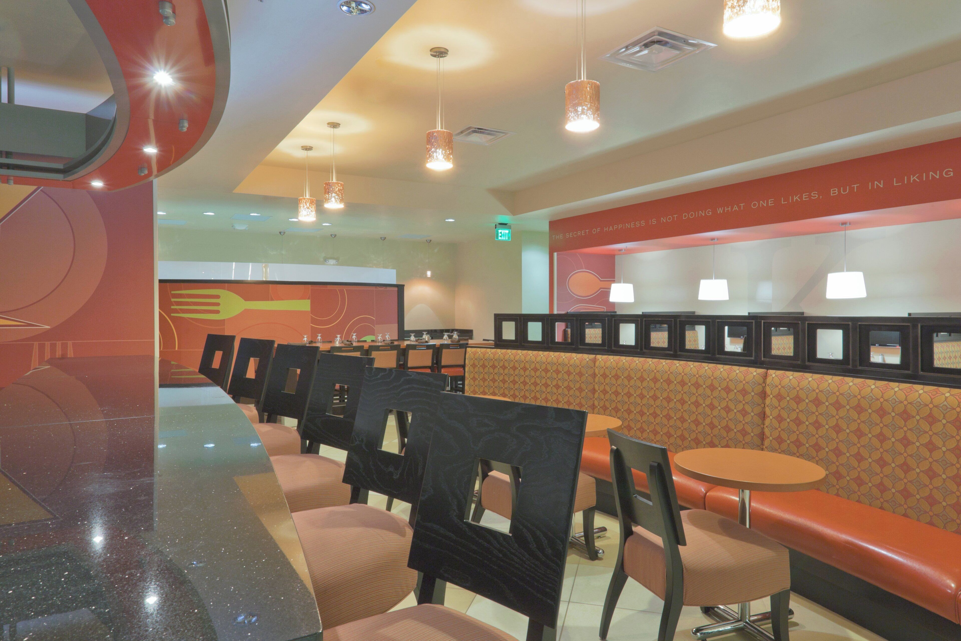 A restaurant interior with booths, tables, and a counter.