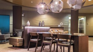 A modern lobby with a reception desk, seating area, and unique geometric pendant lighting. - SpringHill Suites by Marriott Quakertown (Quakertown)
