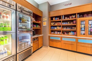 Una kitchenette equipada con refrigerador, microondas y despensa provista de botanas y bebidas.