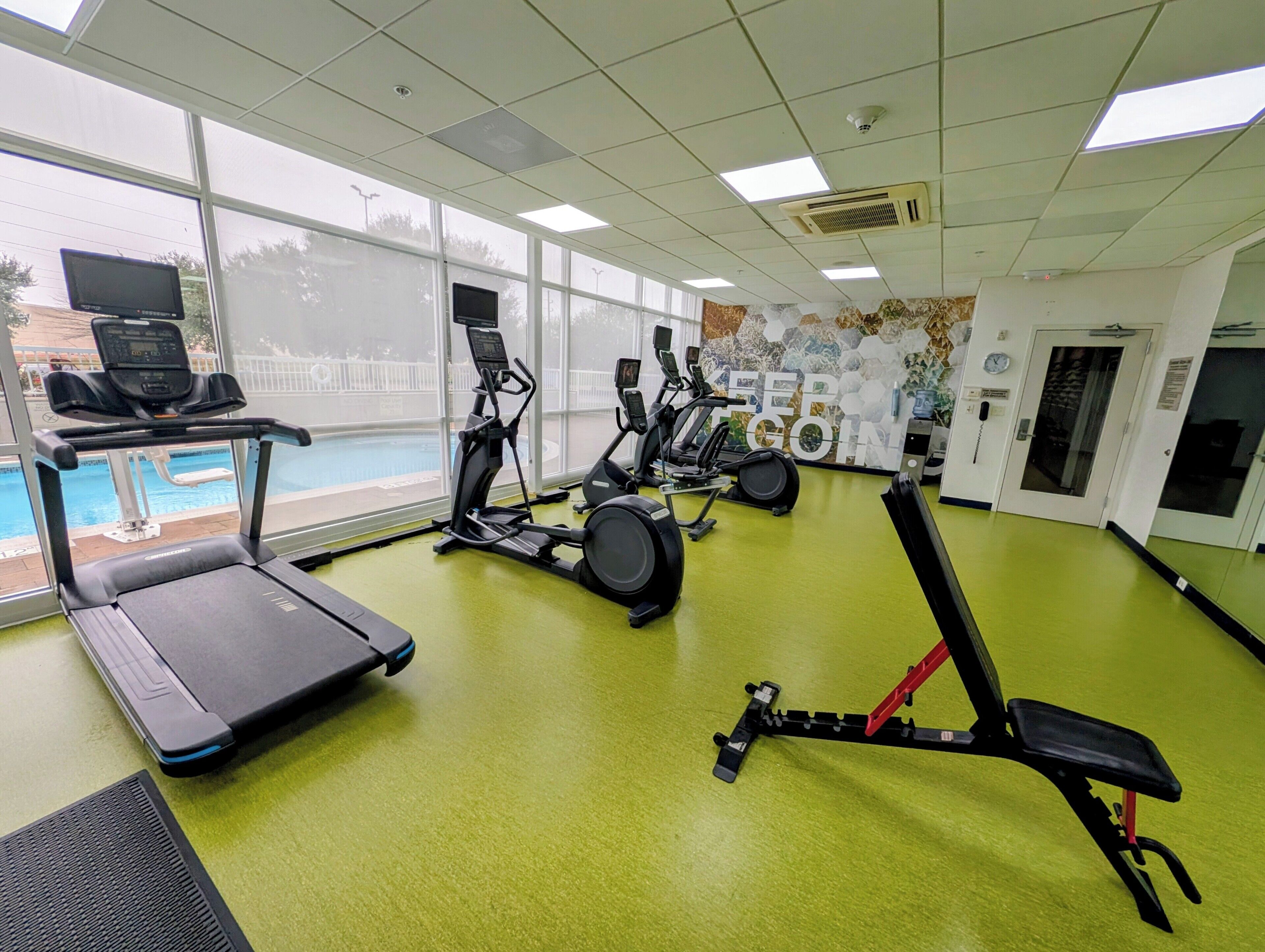A gym with treadmills, elliptical machines, and a stationary bike.