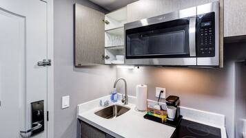 A modern kitchen with a built-in microwave, stainless steel sink, and a dishwasher.
