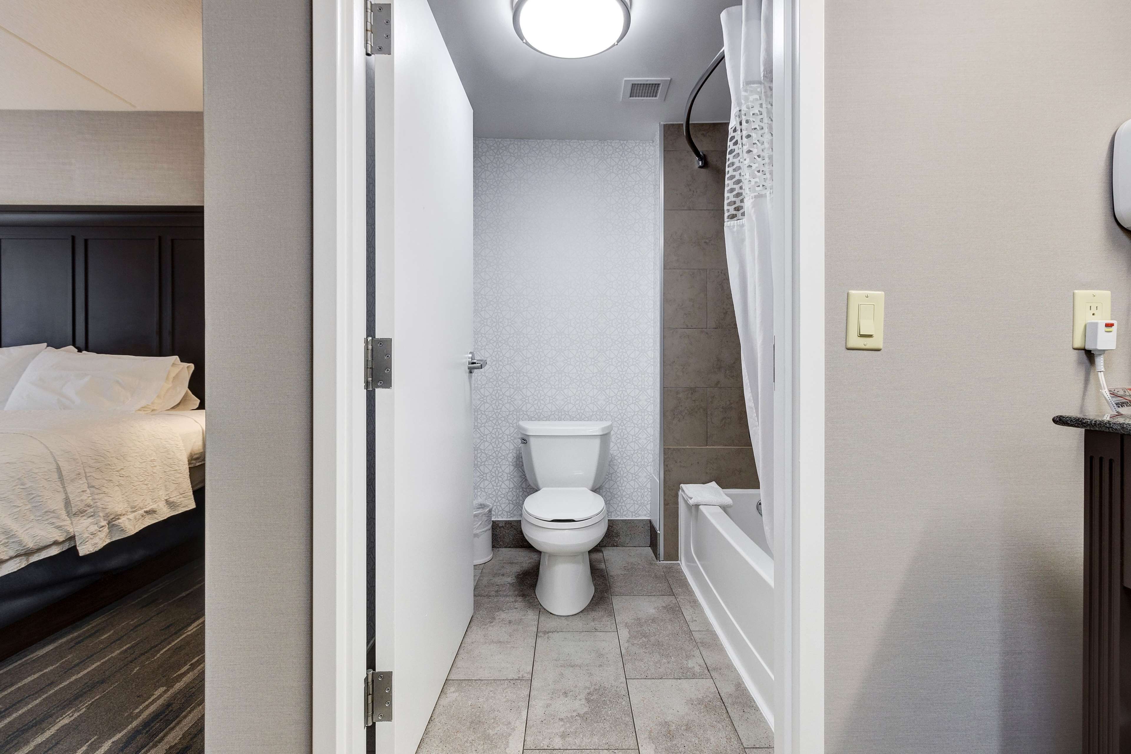 Un baño pequeño con inodoro, ducha con cortina y bañera.