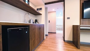 A modern kitchen with a built-in dishwasher, wooden cabinets, and a coffee maker. - Holiday Inn Mexico City - Plaza Universidad by IHG (Mexico City)