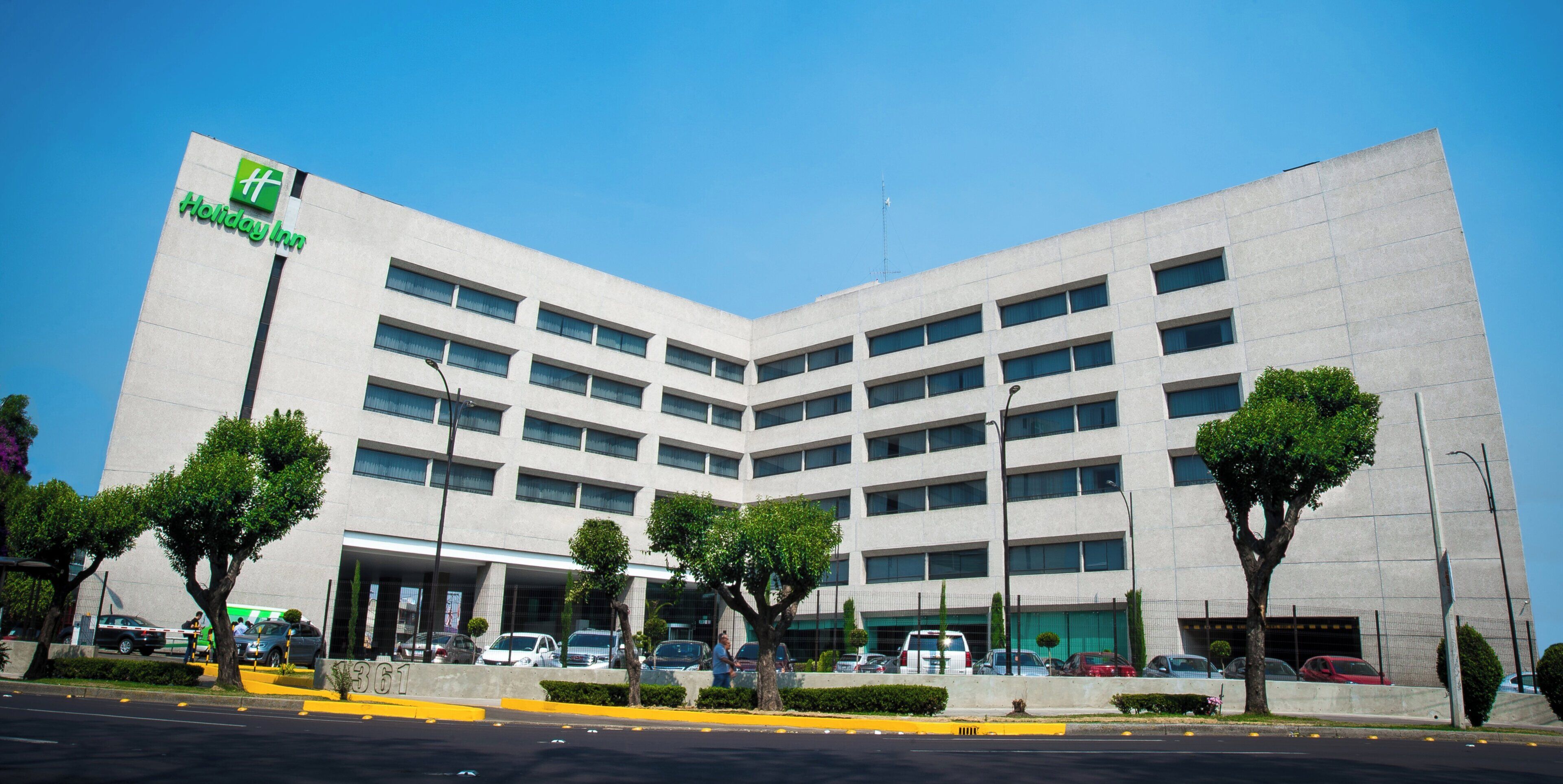 Edificio de un hotel Holiday Inn con un diseño moderno, con varios pisos y una entrada destacada.