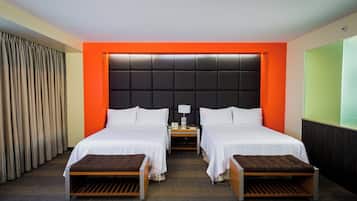 Une chambre d’hôtel avec deux lits, une table de chevet, une lampe et une grande fenêtre.