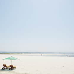 Am Strand, weißer Sandstrand, Liegestühle, Strandtücher