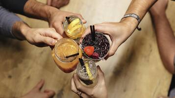 A group of people holding four different drinks, each with unique garnishes.