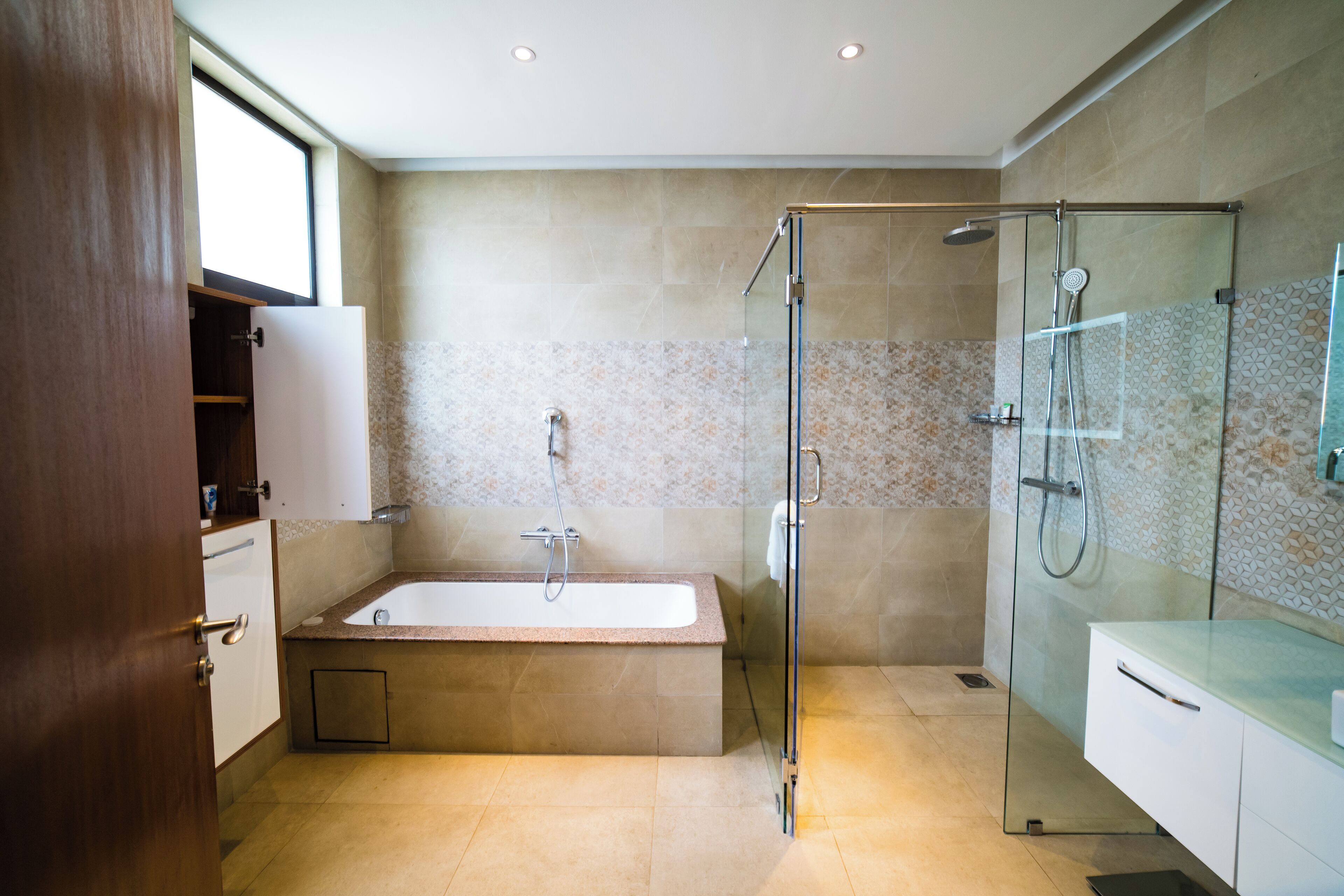 Une salle de bain moderne avec une douche à parois de verre, une baignoire sur pieds et un meuble-lavabo avec un miroir.