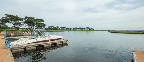 A calm lake with a dock and a boat.