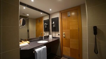 Un baño moderno con dos lavamanos, un espejo, un secador de pelo y un teléfono.