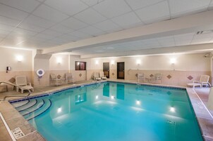 Una piscina techada, sillones reclinables de piscina