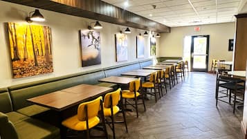 Un interior de restaurante con cabinas, mesas y sillas.
