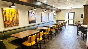 Un interior de restaurante con cabinas, mesas y sillas.