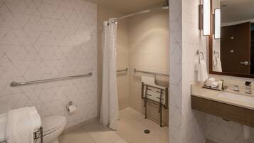 A modern bathroom with a toilet, shower, and sink.