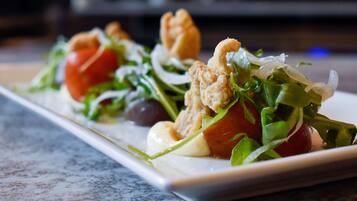 Un plat composé de légumes verts, de tomates et d’une sauce crémeuse.