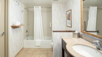 A bathroom with a bathtub, a sink, a shower curtain, and a towel rack.