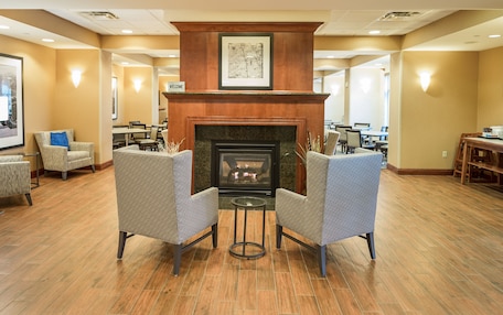 A lobby with a fireplace, seating area, and a 'Welcome' sign.