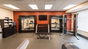 A gym with exercise equipment, a water dispenser, and a mirror. - Hampton Inn Presque Isle Maine (Presque Isle)