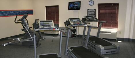A hotel fitness room with treadmills, an elliptical, and a stationary bike.