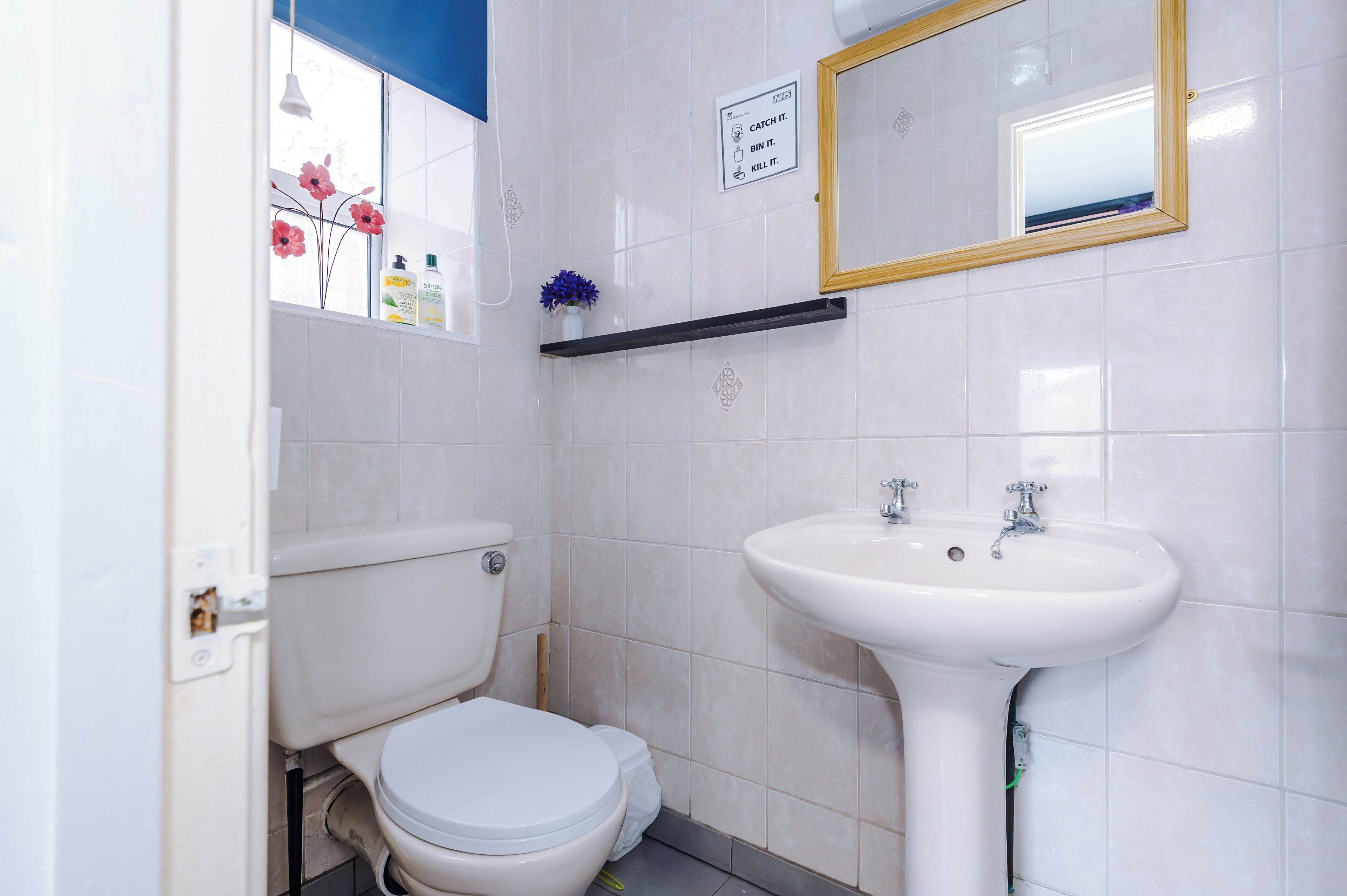 Un baño con inodoro, lavamanos y espejo.
