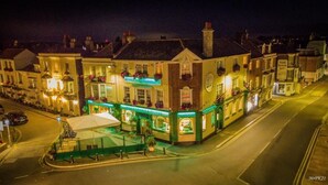 A waterfront hotel with a green facade, multiple balconies with flower boxes, and a prominent sign for 'The Sugar House'. - Dunkerleys Hotel (Deal)
