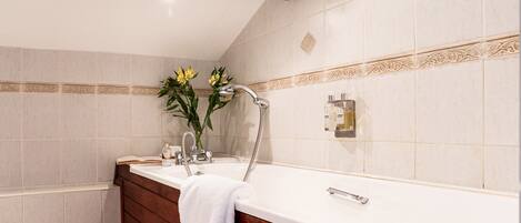 A bathroom with a wooden vanity, a bathtub, and a shower.