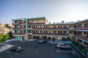 Un motel de varios pisos con estacionamiento.