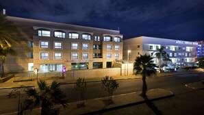 Um hotel moderno com vários andares, janelas amplas e fachada bem iluminada.