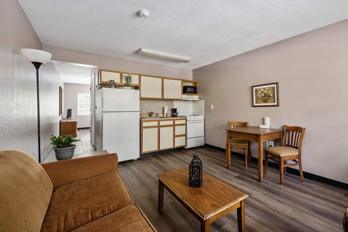 A compact living space with a kitchenette, a dining area, and a seating area.