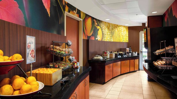 A breakfast buffet with various food items and a fruit display. - Fairfield by Marriott Inn and Suites Augusta Fort Eisenhower Area (Augusta)