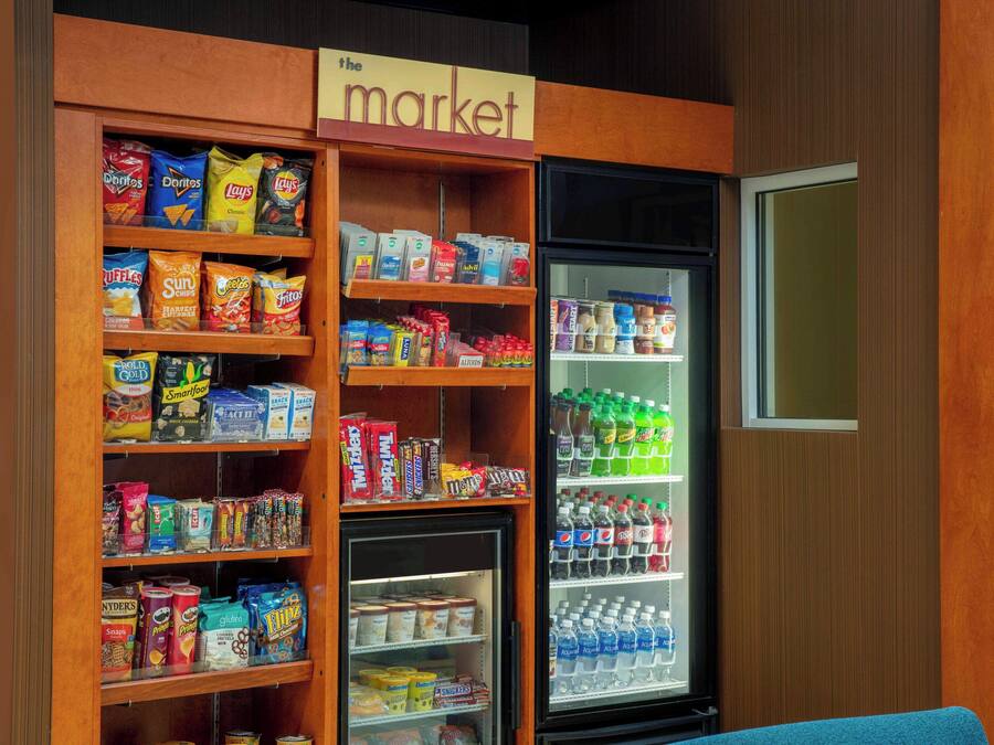 Esposizione di snack e bevande assortite, con patatine, cereali e bevande in bottiglia.