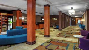 A hotel lobby with a reception desk, a kitchenette, a vending machine, and seating areas. - Fairfield by Marriott Inn and Suites Augusta Fort Eisenhower Area (Augusta)
