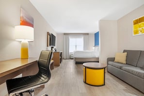 A hotel room with a desk, chair, sofa, TV, bed, and a window with curtains. - Comfort Inn & Suites Dothan Northside Plaza (Dothan)