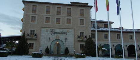Un edificio de piedra con un letrero que dice "Cofremutano" y varias banderas.