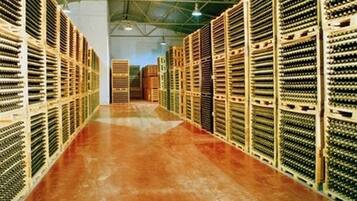 A warehouse with rows of shelving units, a polished concrete floor, and a high ceiling with metal beams.