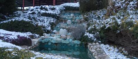 Un espacio exterior cubierto de nieve con una escalera de piedra que conduce a un edificio de techo rojo.