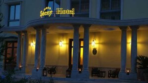 A hotel with a covered entrance, columns, and outdoor seating. - Hotel Seccy Boutique Art & Museum (Fiumicino)
